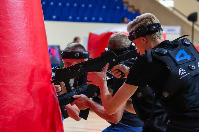 Три бойца LASERWAR в черной форме у красного укрытия.